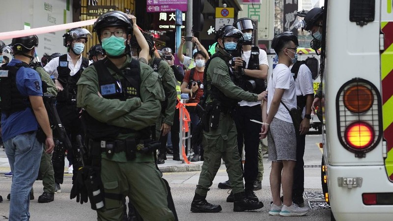 FILE - In this Wednesday, July 1, 2020, file photo, police detain a protester after being pepper sprayed during a protest in Causeway Bay before the annual handover march to mark the 23rd anniversary of Hong Kong's handover to China in 1997. Seven human rights experts affiliated with the U.N. raised concerns over Hong Kong's national security law in a letter addressed to Chinese authorities, saying that the law infringed on certain fundamental rights. (AP Photo/Vincent Yu, file)