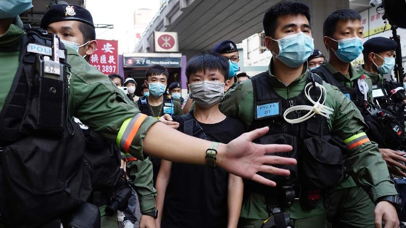 FILE - In this Wednesday, July 1, 2020, file photo, police detain a protester after being pepper sprayed during a protest in Causeway Bay before the annual handover march to mark the 23rd anniversary of Hong Kong's handover to China in 1997. Seven human rights experts affiliated with the U.N. raised concerns over Hong Kong's national security law in a letter addressed to Chinese authorities, saying that the law infringed on certain fundamental rights. (AP Photo/Vincent Yu, file)