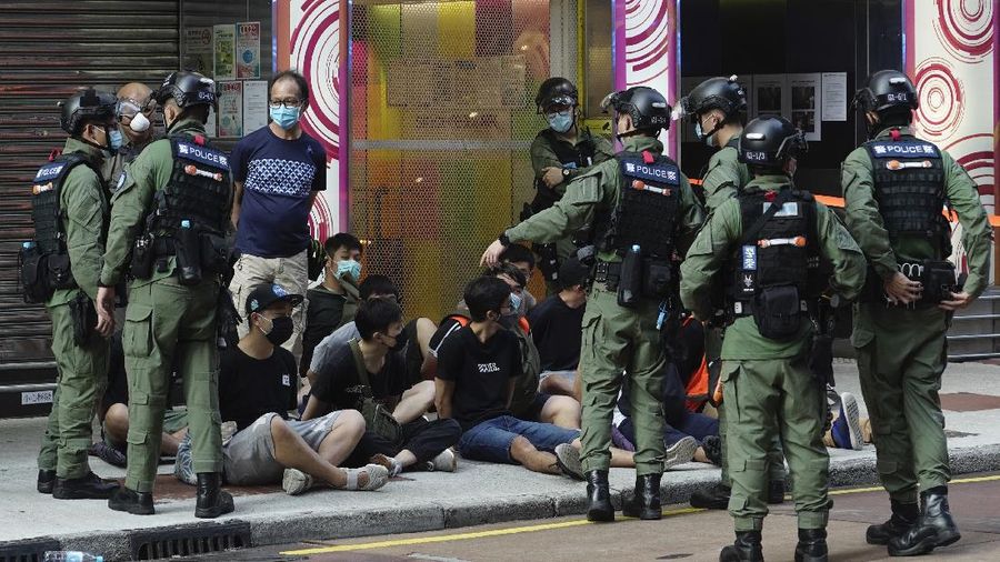 FILE - In this Wednesday, July 1, 2020, file photo, police detain a protester after being pepper sprayed during a protest in Causeway Bay before the annual handover march to mark the 23rd anniversary of Hong Kong's handover to China in 1997. Seven human rights experts affiliated with the U.N. raised concerns over Hong Kong's national security law in a letter addressed to Chinese authorities, saying that the law infringed on certain fundamental rights. (AP Photo/Vincent Yu, file)