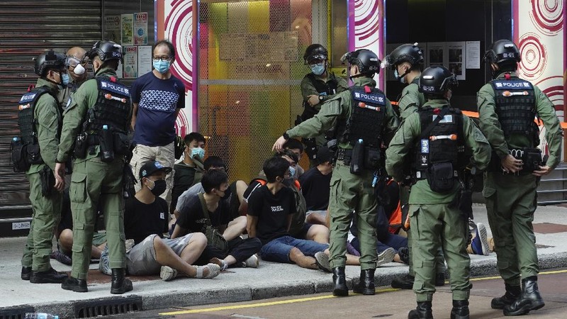 FILE - In this Wednesday, July 1, 2020, file photo, police detain a protester after being pepper sprayed during a protest in Causeway Bay before the annual handover march to mark the 23rd anniversary of Hong Kong's handover to China in 1997. Seven human rights experts affiliated with the U.N. raised concerns over Hong Kong's national security law in a letter addressed to Chinese authorities, saying that the law infringed on certain fundamental rights. (AP Photo/Vincent Yu, file)