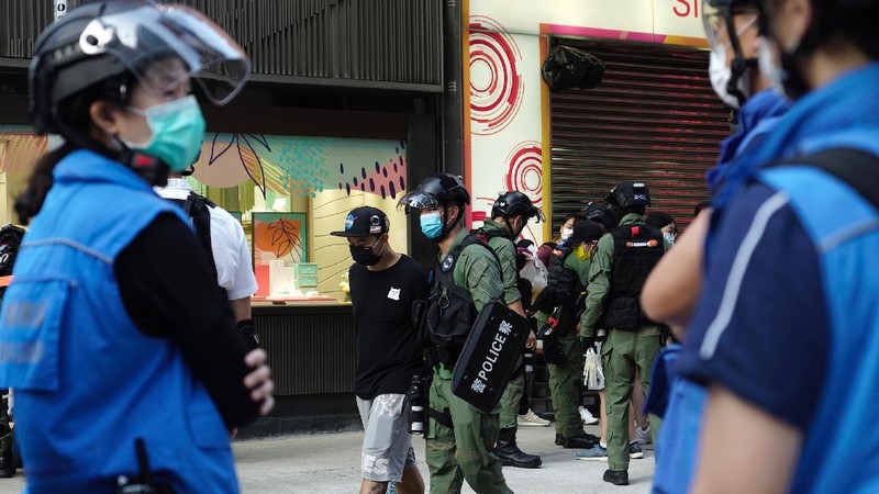 FILE - In this Wednesday, July 1, 2020, file photo, police detain a protester after being pepper sprayed during a protest in Causeway Bay before the annual handover march to mark the 23rd anniversary of Hong Kong's handover to China in 1997. Seven human rights experts affiliated with the U.N. raised concerns over Hong Kong's national security law in a letter addressed to Chinese authorities, saying that the law infringed on certain fundamental rights. (AP Photo/Vincent Yu, file)