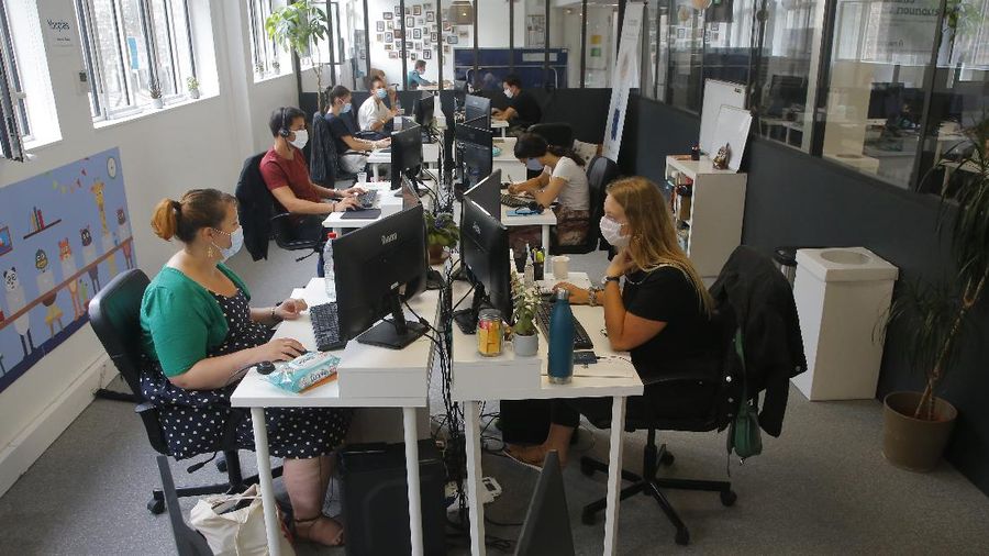 Employees wear masks in startup company Yoopies, Wednesday Aug.19, 2020 in Paris. France is now mandating masks in all workplaces, from the Paris business district to factories in the provinces. The government is trying to contain growing virus infections but avoid shutting down the economy. The announcement makes France one of relatively few countries that's universally requiring workers to wear masks on the job, though they're routinely worn in many Asian countries. (AP Photo/Michel Euler)
