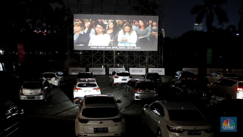 Sejumlah mobil terparkir di bioskop Skylight Cinema Senayan Park, Jakarta, Rabu (9/9/2020). Pandemi Covid-19 menimbulkan gaya hidup baru dalam menonton film. (CNBC Indonesia/Tri Susilo)

Gaya hidup baru menonton film itu dapat disaksikan di mall terbaru di Jakarta Pusat bernama Senayan Park, Sebuah bioskop dengan konsep drive in ditampilkan.  

Bioskop bernama Skylight Cinema itu hadir mulai 5 September sampai 30 September 2020.

Di bioskop tersebut penonton tidak mendapatkan bangku untuk menonton film. Melainkan mereka akan menonton di dalam mobil masing-masing yang diparkir di sebuah halaman luas.

Skylight Cinema menyediakan dua cinema yang dapat menampung 105 mobil setiap sesinya.

Ada dua sesi pemutaran film setiap harinya yakni sesi pukul 18.30 WIB dan sesi 21.30 WIB.   

Sehingga total ada 210 mobil dapat ditampung setiap hari dalam pemutaran film di Skylight Cinema.

Mobil-mobil terlihat mengantre masuk ke sebuah halaman cinema. Sebelum masuk para penonton dicek suhu tubuh terlebih dahulu.

Para penonton juga wajib menggunakan masker dan membawa handsanitizer sebelum mobil mereka masuk cinema. (CNBC Indonesia/Tri Susilo)