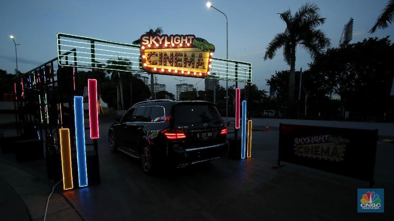 Sejumlah mobil terparkir di bioskop Skylight Cinema Senayan Park, Jakarta, Rabu (9/9/2020). Pandemi Covid-19 menimbulkan gaya hidup baru dalam menonton film. (CNBC Indonesia/Tri Susilo)

Gaya hidup baru menonton film itu dapat disaksikan di mall terbaru di Jakarta Pusat bernama Senayan Park, Sebuah bioskop dengan konsep drive in ditampilkan.  

Bioskop bernama Skylight Cinema itu hadir mulai 5 September sampai 30 September 2020.

Di bioskop tersebut penonton tidak mendapatkan bangku untuk menonton film. Melainkan mereka akan menonton di dalam mobil masing-masing yang diparkir di sebuah halaman luas.

Skylight Cinema menyediakan dua cinema yang dapat menampung 105 mobil setiap sesinya.

Ada dua sesi pemutaran film setiap harinya yakni sesi pukul 18.30 WIB dan sesi 21.30 WIB.   

Sehingga total ada 210 mobil dapat ditampung setiap hari dalam pemutaran film di Skylight Cinema.

Mobil-mobil terlihat mengantre masuk ke sebuah halaman cinema. Sebelum masuk para penonton dicek suhu tubuh terlebih dahulu.

Para penonton juga wajib menggunakan masker dan membawa handsanitizer sebelum mobil mereka masuk cinema. (CNBC Indonesia/Tri Susilo)