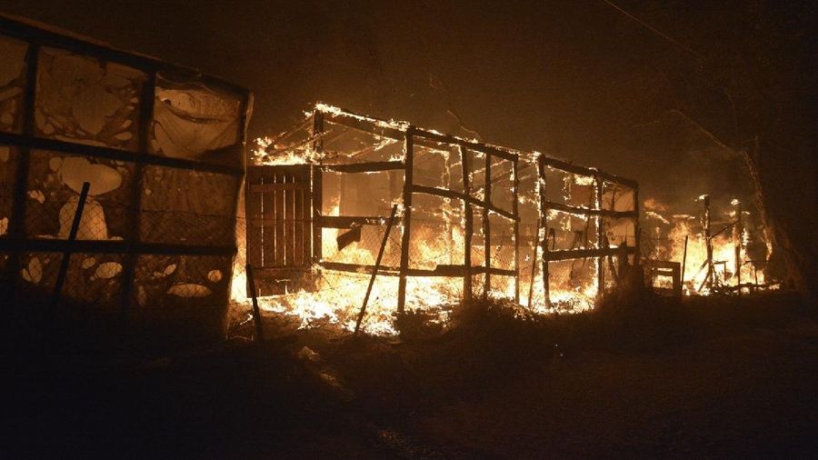 Firefighters try to extinguish a fire in the Moria refugee camp on the northeastern Aegean island of Lesbos, Greece, on Wednesday, Sept. 9, 2020. A fire swept through Greece's largest refugee camp that had been placed under COVID-19 lockdown, leaving more than 12,000 migrants in emergency need of shelter on the island of Lesbos. (AP Photo/Panagiotis Balaskas)