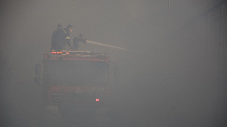 Firefighters try to extinguish a fire in the Moria refugee camp on the northeastern Aegean island of Lesbos, Greece, on Wednesday, Sept. 9, 2020. A fire swept through Greece's largest refugee camp that had been placed under COVID-19 lockdown, leaving more than 12,000 migrants in emergency need of shelter on the island of Lesbos. (AP Photo/Panagiotis Balaskas)