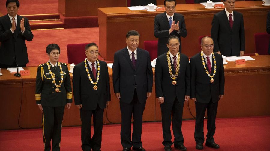 Attendees wearing face masks arrive for an event to honor some of those involved in China's fight against COVID-19 at the Great Hall of the People in Beijing, Tuesday, Sept. 8, 2020. Chinese leader Xi Jinping is praising China's role in battling the global coronavirus pandemic and expressing support for the U.N.'s World Health Organization, in a repudiation of U.S. criticism and a bid to rally domestic support for Communist Party leadership. (AP Photo/Mark Schiefelbein)