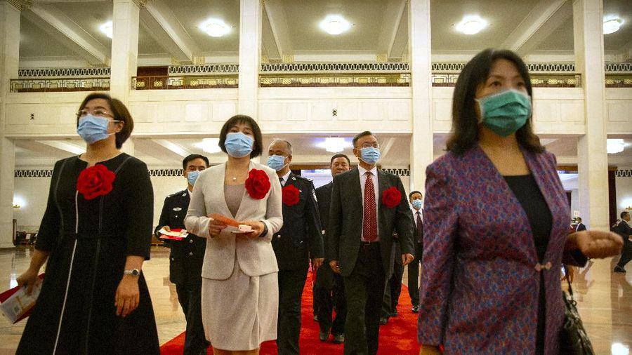 Attendees wearing face masks arrive for an event to honor some of those involved in China's fight against COVID-19 at the Great Hall of the People in Beijing, Tuesday, Sept. 8, 2020. Chinese leader Xi Jinping is praising China's role in battling the global coronavirus pandemic and expressing support for the U.N.'s World Health Organization, in a repudiation of U.S. criticism and a bid to rally domestic support for Communist Party leadership. (AP Photo/Mark Schiefelbein)