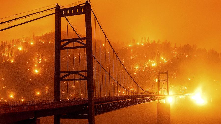 A firefighter battles the Creek Fire as it threatens homes in the Cascadel Woods neighborhood of Madera County, Calif., on Monday, Sept. 7, 2020. (AP Photo/Noah Berger)