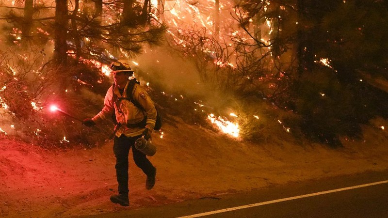 A firefighter battles the Creek Fire as it threatens homes in the Cascadel Woods neighborhood of Madera County, Calif., on Monday, Sept. 7, 2020. (AP Photo/Noah Berger)