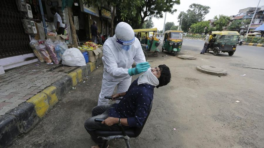A health worker takes a nasal swab sample to test for COVID-19 in Ahmedabad, India, Tuesday, Sept. 8, 2020. India's coronavirus cases are now the second-highest in the world and only behind the United States. (AP Photo/Ajit Solanki)