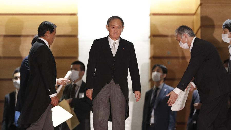 Japan's new Prime Minister Yoshihide Suga, center, walks out after attending an extraordinary session at the upper house of parliament Thursday, Sept. 17, 2020, in Tokyo. Suga started his first full day in office Thursday, with a resolve to push for reforms for the people, and he said he is already taking a crack at it. (AP Photo/Eugene Hoshiko)
