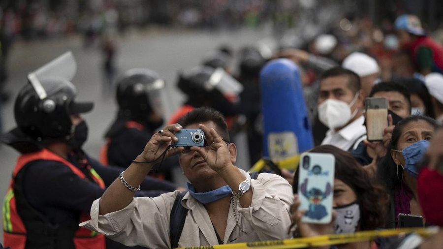 Medical workers who tend to COVID-19 patients and who received a medal from the government as recognition for their efforts pose for a photo with an Army mascot during the annual Independence Day military parade in Mexico City’s main square of the capital, the Zócalo, Wednesday, Sept. 16, 2020. Mexico celebrates the anniversary of its independence uprising of 1810. ( AP Photo/Marco Ugarte)