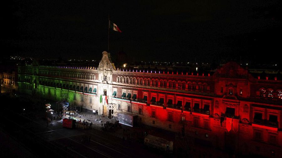 Medical workers who tend to COVID-19 patients and who received a medal from the government as recognition for their efforts pose for a photo with an Army mascot during the annual Independence Day military parade in Mexico City’s main square of the capital, the Zócalo, Wednesday, Sept. 16, 2020. Mexico celebrates the anniversary of its independence uprising of 1810. ( AP Photo/Marco Ugarte)