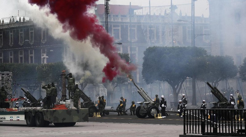 Medical workers who tend to COVID-19 patients and who received a medal from the government as recognition for their efforts pose for a photo with an Army mascot during the annual Independence Day military parade in Mexico City’s main square of the capital, the Zócalo, Wednesday, Sept. 16, 2020. Mexico celebrates the anniversary of its independence uprising of 1810. ( AP Photo/Marco Ugarte)
