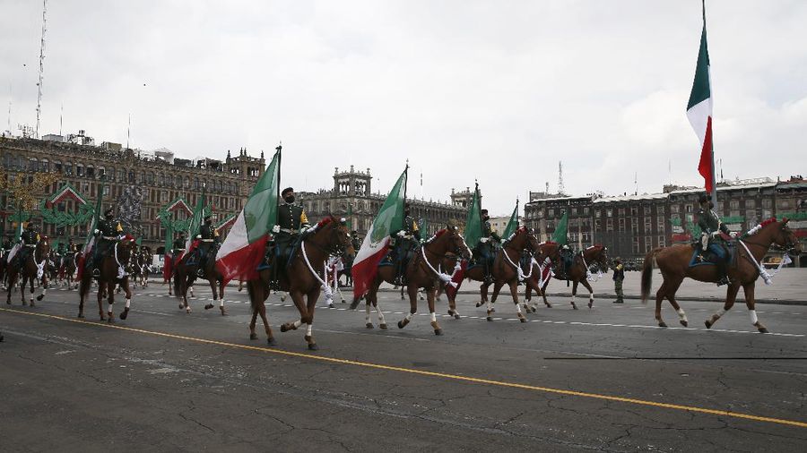 Medical workers who tend to COVID-19 patients and who received a medal from the government as recognition for their efforts pose for a photo with an Army mascot during the annual Independence Day military parade in Mexico City’s main square of the capital, the Zócalo, Wednesday, Sept. 16, 2020. Mexico celebrates the anniversary of its independence uprising of 1810. ( AP Photo/Marco Ugarte)