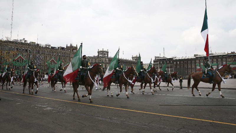 Medical workers who tend to COVID-19 patients and who received a medal from the government as recognition for their efforts pose for a photo with an Army mascot during the annual Independence Day military parade in Mexico City’s main square of the capital, the Zócalo, Wednesday, Sept. 16, 2020. Mexico celebrates the anniversary of its independence uprising of 1810. ( AP Photo/Marco Ugarte)