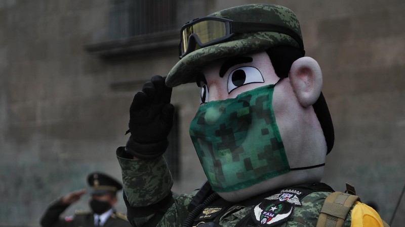 Medical workers who tend to COVID-19 patients and who received a medal from the government as recognition for their efforts pose for a photo with an Army mascot during the annual Independence Day military parade in Mexico City’s main square of the capital, the Zócalo, Wednesday, Sept. 16, 2020. Mexico celebrates the anniversary of its independence uprising of 1810. ( AP Photo/Marco Ugarte)