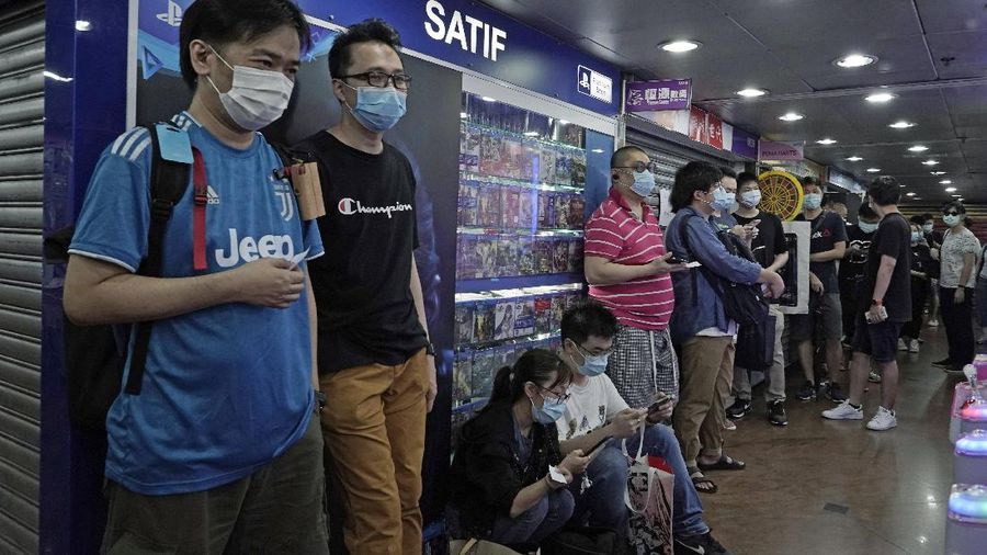 Gaming enthusiasts queue up for the pre-order sales of the newly unveiled Japanese brand video game console, Sony's PlayStation 5 (PS5), outside a retailer in Hong Kong, Friday, Sept. 18, 2020. Pre-orders of PlayStation 5 started on Sept. 17 and will be filled on Nov. 19. (AP Photo/Kin Cheung)