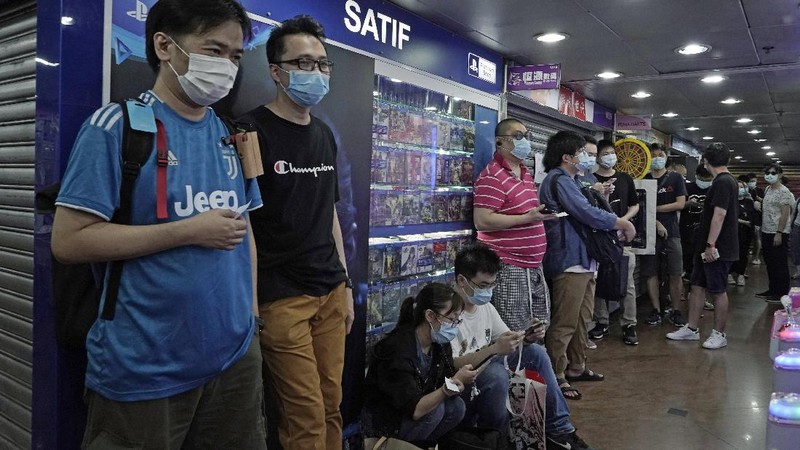 Gaming enthusiasts queue up for the pre-order sales of the newly unveiled Japanese brand video game console, Sony's PlayStation 5 (PS5), outside a retailer in Hong Kong, Friday, Sept. 18, 2020. Pre-orders of PlayStation 5 started on Sept. 17 and will be filled on Nov. 19. (AP Photo/Kin Cheung)