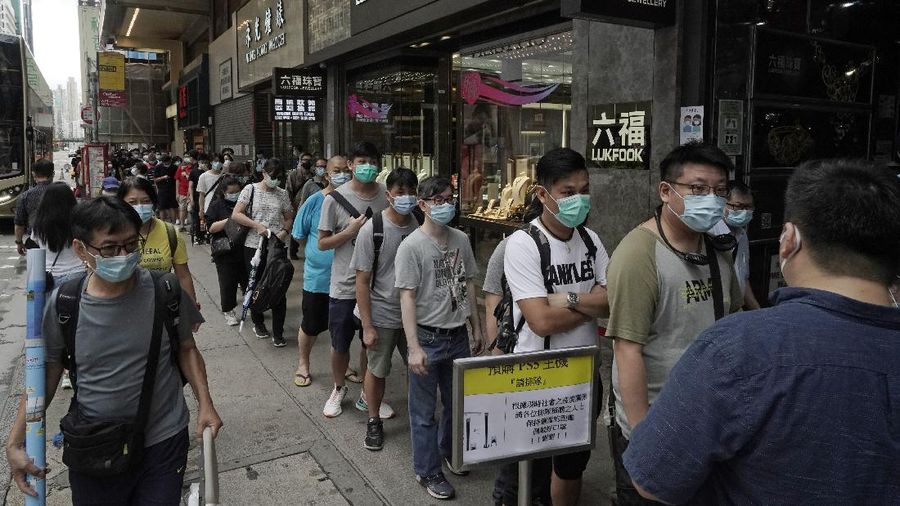 Gaming enthusiasts queue up for the pre-order sales of the newly unveiled Japanese brand video game console, Sony's PlayStation 5 (PS5), outside a retailer in Hong Kong, Friday, Sept. 18, 2020. Pre-orders of PlayStation 5 started on Sept. 17 and will be filled on Nov. 19. (AP Photo/Kin Cheung)