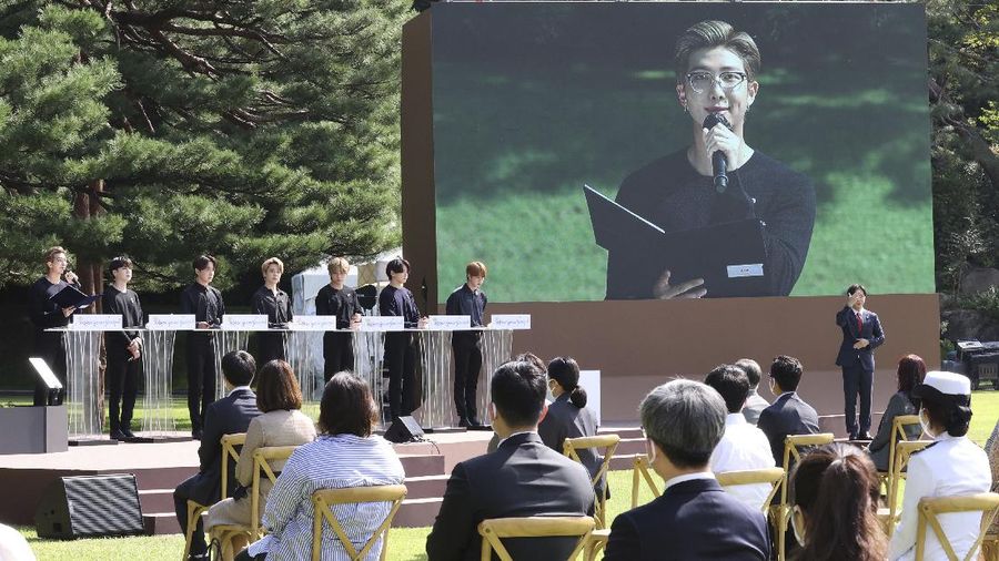 South Korean President Moon Jae-in, third from left, receives a gift from members of South Korean K-Pop group BTS during a ceremony marking the National Youth Day at the presidential Blue House in Seoul, South Korea, Saturday, Sept. 19, 2020. (Lee Jin-wook/Yonhap via AP)