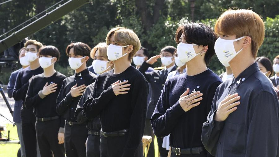 South Korean President Moon Jae-in, third from left, receives a gift from members of South Korean K-Pop group BTS during a ceremony marking the National Youth Day at the presidential Blue House in Seoul, South Korea, Saturday, Sept. 19, 2020. (Lee Jin-wook/Yonhap via AP)