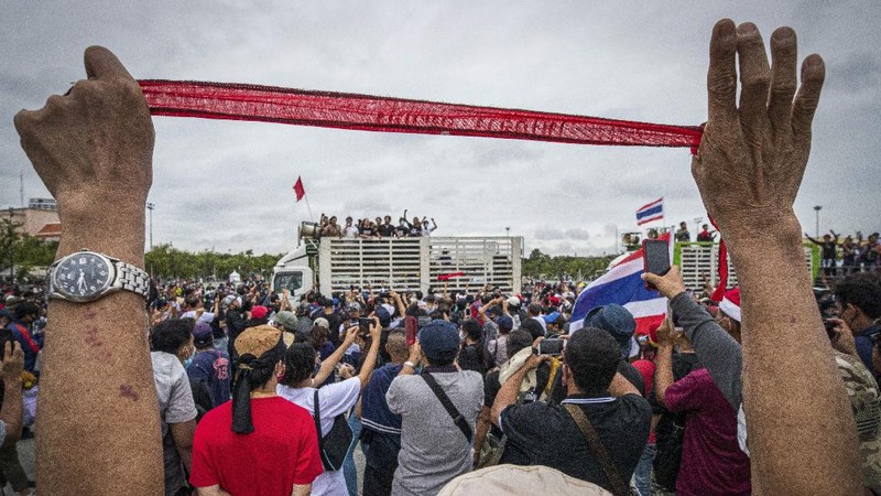 Pro-democracy protesters gesture as they listens to students leaders speech during a protest in Bangkok, Thailand, Sunday, Sept. 20, 2020. The mass student-led rally that began Saturday is the largest in a series of protests this year, with thousands camping overnight near the royal palace, demanding for new elections and reform of the monarchy. (AP Photo/Wason Wanichakorn)