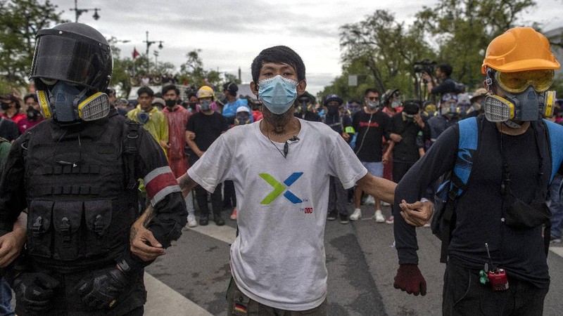 Pro-democracy protesters gesture as they listens to students leaders speech during a protest in Bangkok, Thailand, Sunday, Sept. 20, 2020. The mass student-led rally that began Saturday is the largest in a series of protests this year, with thousands camping overnight near the royal palace, demanding for new elections and reform of the monarchy. (AP Photo/Wason Wanichakorn)