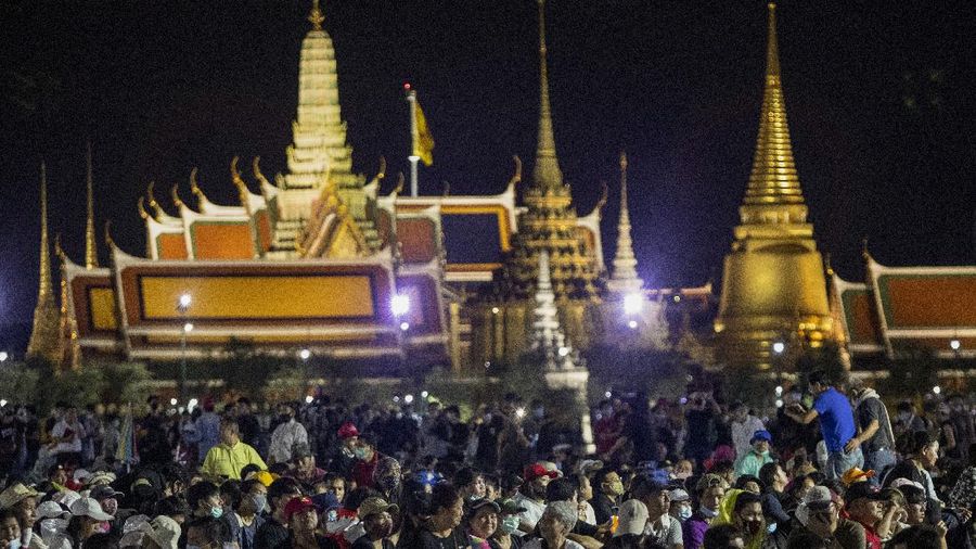Pro-democracy demonstrators attend a protest at Sanam Luang with The Grand Palace lit up in the background in Bangkok, Thailand, Saturday, Sept. 19, 2020. Thousands of demonstrators turned out Saturday for a rally to support the student-led protest movement's demands for new elections and reform of the monarchy. (AP Photo/Sakchai Lalit)