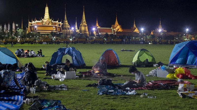 Pro-democracy protesters gesture as they listens to students leaders speech during a protest in Bangkok, Thailand, Sunday, Sept. 20, 2020. The mass student-led rally that began Saturday is the largest in a series of protests this year, with thousands camping overnight near the royal palace, demanding for new elections and reform of the monarchy. (AP Photo/Wason Wanichakorn)
