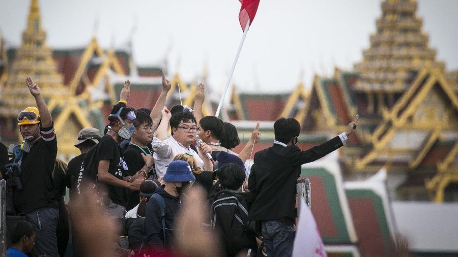 Pro-democracy protesters gesture as they listens to students leaders speech during a protest in Bangkok, Thailand, Sunday, Sept. 20, 2020. The mass student-led rally that began Saturday is the largest in a series of protests this year, with thousands camping overnight near the royal palace, demanding for new elections and reform of the monarchy. (AP Photo/Wason Wanichakorn)