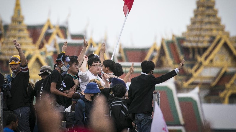 Pro-democracy protesters gesture as they listens to students leaders speech during a protest in Bangkok, Thailand, Sunday, Sept. 20, 2020. The mass student-led rally that began Saturday is the largest in a series of protests this year, with thousands camping overnight near the royal palace, demanding for new elections and reform of the monarchy. (AP Photo/Wason Wanichakorn)