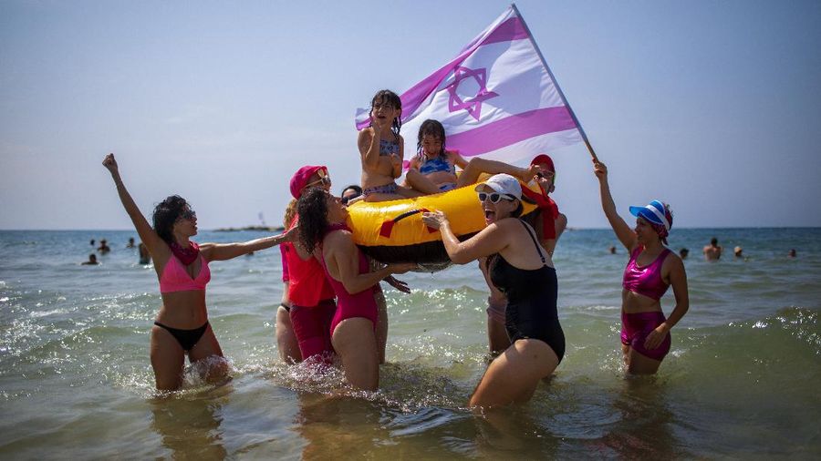 Acrobats perform as they wear face masks during a protest against government's decision to close beaches during the three-week nationwide lockdown due to the coronavirus pandemic, in Tel Aviv, Israel, Saturday, Sept 19, 2020. Israel went back into a full lockdown on Friday to try to contain a coronavirus outbreak that has steadily worsened for months as its government has been plagued by indecision and infighting. (AP Photo/Oded Balilty)