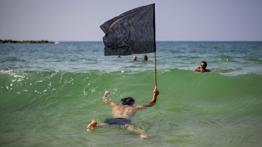 Acrobats perform as they wear face masks during a protest against government's decision to close beaches during the three-week nationwide lockdown due to the coronavirus pandemic, in Tel Aviv, Israel, Saturday, Sept 19, 2020. Israel went back into a full lockdown on Friday to try to contain a coronavirus outbreak that has steadily worsened for months as its government has been plagued by indecision and infighting. (AP Photo/Oded Balilty)
