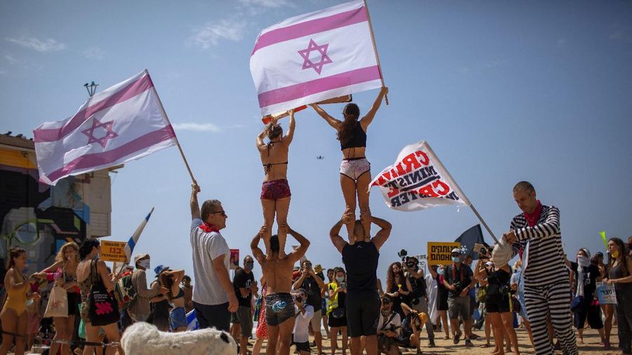 Acrobats perform as they wear face masks during a protest against government's decision to close beaches during the three-week nationwide lockdown due to the coronavirus pandemic, in Tel Aviv, Israel, Saturday, Sept 19, 2020. Israel went back into a full lockdown on Friday to try to contain a coronavirus outbreak that has steadily worsened for months as its government has been plagued by indecision and infighting. (AP Photo/Oded Balilty)