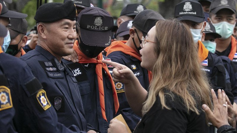 Pro-democracy protesters, some in protective tear-gas masks form a human chain during a street march close to Sanam Luang in Bangkok, Thailand, Sunday, Sept. 20, 2020. The mass student-led rally that began Saturday is the largest in a series of protests this year, with thousands camping overnight near the royal palace, demanding for new elections and reform of the monarchy.(AP Photo/Gemunu Amarasinghe)