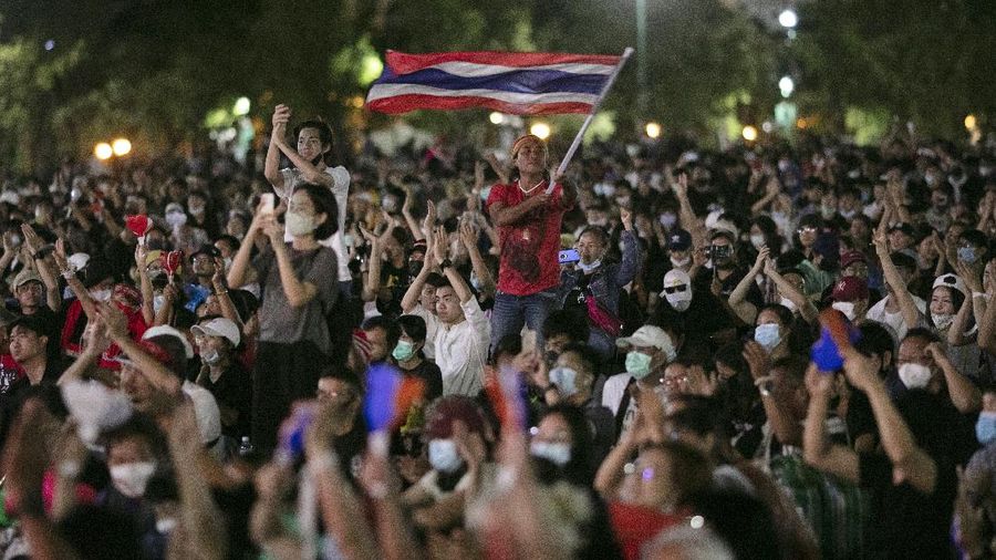 Pro-democracy protesters wave the national flag at the Sanam Luang field during a protest in Bangkok, Thailand, Saturday, Sept. 19, 2020. Thousands of demonstrators turned out Saturday for a rally to support the student-led protest movement's demands for new elections and reform of the monarchy. (AP Photo/Wason Wanichakorn)