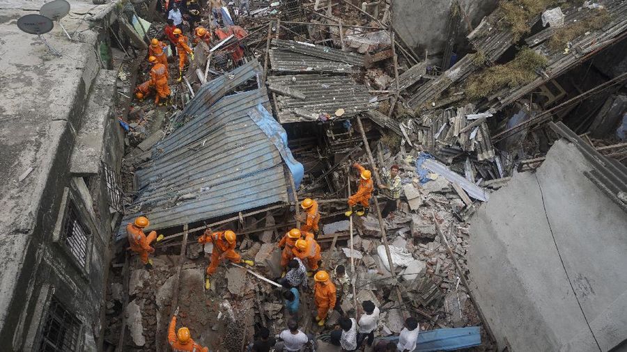 This photograph provided by India’s National Disaster Response Force (NDRF) shows rescuers at the site after a residential building collapsed in Bhiwandi in Thane district, a suburb of Mumbai, India, Monday, Sept.21, 2020. (National Disaster Response Force via AP)