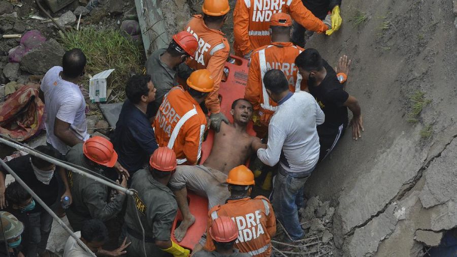 This photograph provided by India’s National Disaster Response Force (NDRF) shows rescuers at the site after a residential building collapsed in Bhiwandi in Thane district, a suburb of Mumbai, India, Monday, Sept.21, 2020. (National Disaster Response Force via AP)