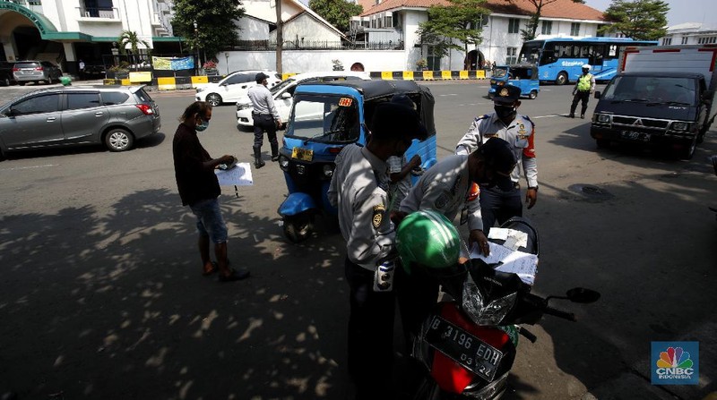 Petugas gabungan melakukan oprasi yustisi 2020 pencegahan Covid-19 dikawasan Kota Tua, Jakarta. Oprasi ini menuju angkutan umum yang penumpangnya melebihi 50 persen kapasitas angkutan, Senin (21/9/2020). (CNBC Indonesia/Tri Susilo)