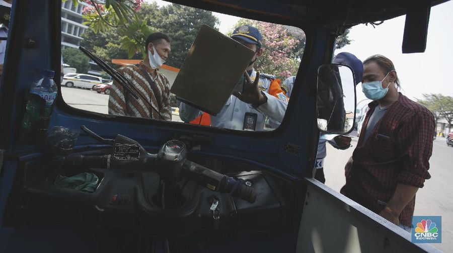 Petugas gabungan melakukan oprasi yustisi 2020 pencegahan Covid-19 dikawasan Kota Tua, Jakarta. Oprasi ini menuju angkutan umum yang penumpangnya melebihi 50 persen kapasitas angkutan, Senin (21/9/2020). (CNBC Indonesia/Tri Susilo)