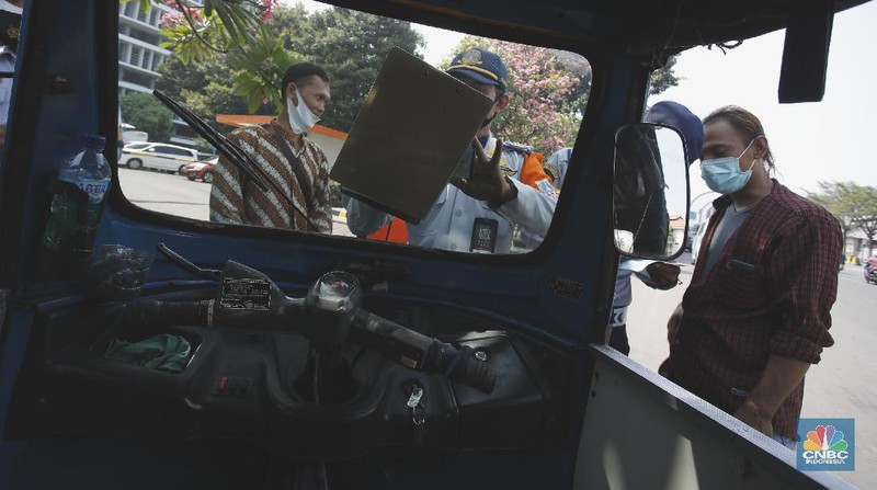 Petugas gabungan melakukan oprasi yustisi 2020 pencegahan Covid-19 dikawasan Kota Tua, Jakarta. Oprasi ini menuju angkutan umum yang penumpangnya melebihi 50 persen kapasitas angkutan, Senin (21/9/2020). (CNBC Indonesia/Tri Susilo)