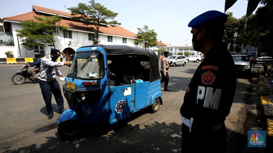 Petugas gabungan melakukan oprasi yustisi 2020 pencegahan Covid-19 dikawasan Kota Tua, Jakarta. Oprasi ini menuju angkutan umum yang penumpangnya melebihi 50 persen kapasitas angkutan, Senin (21/9/2020). (CNBC Indonesia/Tri Susilo)