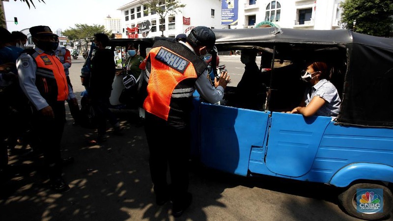 Petugas gabungan melakukan oprasi yustisi 2020 pencegahan Covid-19 dikawasan Kota Tua, Jakarta. Oprasi ini menuju angkutan umum yang penumpangnya melebihi 50 persen kapasitas angkutan, Senin (21/9/2020). (CNBC Indonesia/Tri Susilo)
