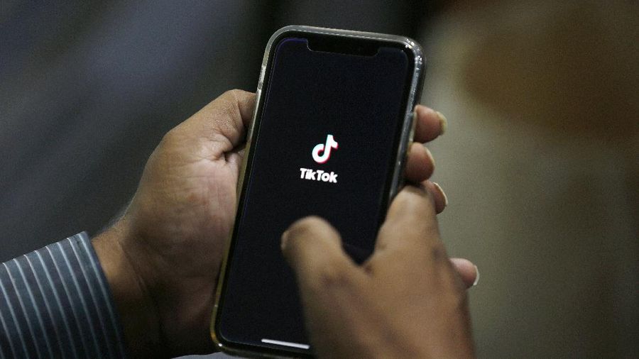 FILE - In this July 21, 2020 file photo, a man opens social media app 'TikTok' on his cell phone, in Islamabad, Pakistan. President Donald Trump said Saturday, Sept. 19, 2020 he’s given his “blessing” to a proposed deal between Oracle and Walmart for the U.S. operations of TikTok, the Chinese-owned app he’s targeted for national security and data privacy concerns. (AP Photo/Anjum Naveed, File)