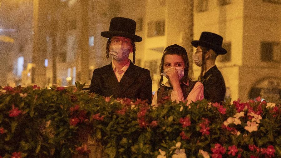 Garbage burns as ultra-Orthodox Jews protest against the restrictions on gatherings for public prayers despite a new nationwide lockdown order aimed at curbing a raging coronavirus outbreak in Bnei Brak, Israel, Sunday, Sept. 20, 2020. In the ultra-Orthodox town of Bnei Brak near Israel's commercial hub of Tel Aviv, over 100 activists took to the streets and burned garbage to protest restrictions on gatherings for public prayers. (AP Photo/Ariel Schalit)