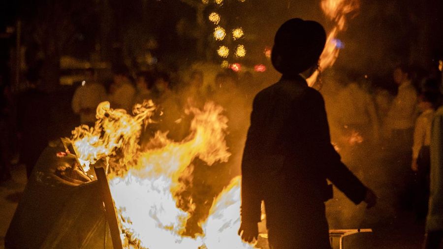 Garbage burns as ultra-Orthodox Jews protest against the restrictions on gatherings for public prayers despite a new nationwide lockdown order aimed at curbing a raging coronavirus outbreak in Bnei Brak, Israel, Sunday, Sept. 20, 2020. In the ultra-Orthodox town of Bnei Brak near Israel's commercial hub of Tel Aviv, over 100 activists took to the streets and burned garbage to protest restrictions on gatherings for public prayers. (AP Photo/Ariel Schalit)