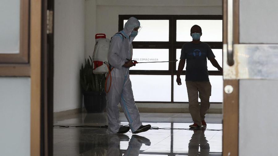 A health worker walks inside a quarantine facility for people showing symptoms of the COVID-19 amid the coronavirus outbreak at Patriot Candrabhaga stadium in Bekasi on the outskirts of Jakarta, Indonesia, Tuesday, Sept. 22, 2020.(AP Photo/Achmad Ibrahim)