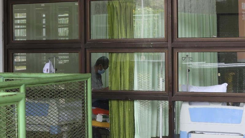 A health worker walks inside a quarantine facility for people showing symptoms of the COVID-19 amid the coronavirus outbreak at Patriot Candrabhaga stadium in Bekasi on the outskirts of Jakarta, Indonesia, Tuesday, Sept. 22, 2020.(AP Photo/Achmad Ibrahim)